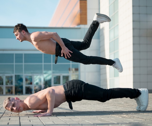 Side view of shirtless hip hop performers dancing