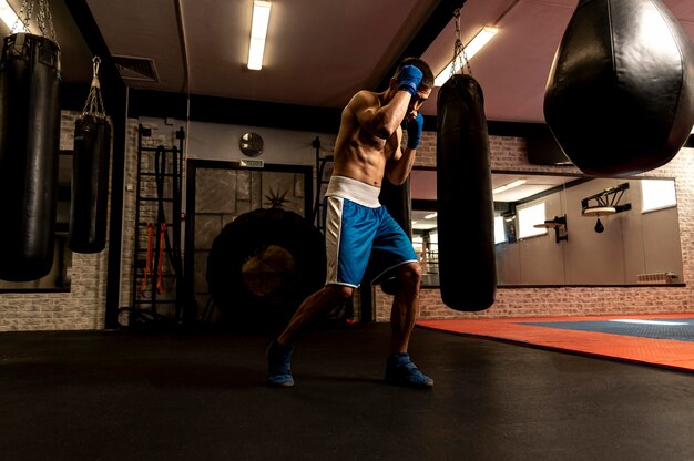 Side view of shirtless male boxer training
