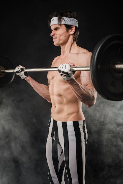 Side view of shirtless man lifting weights