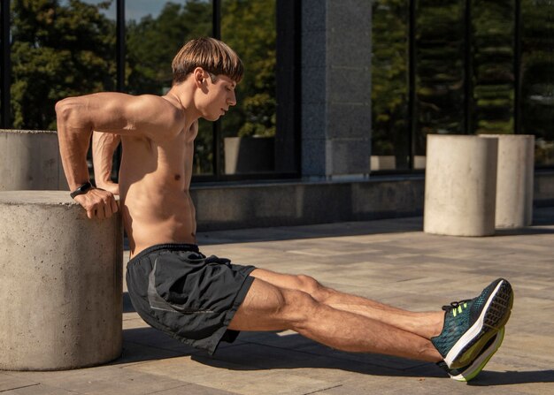 Side view of shirtless man training outside