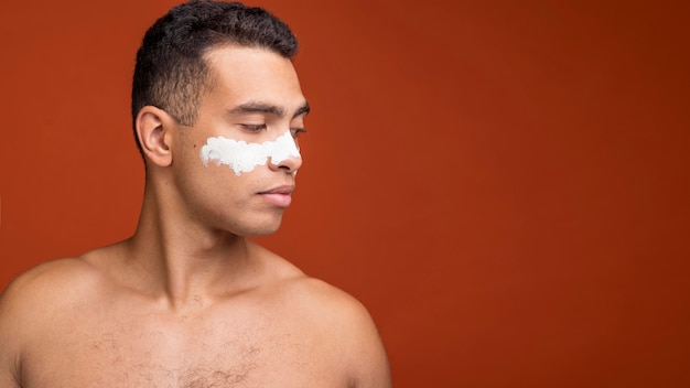 Free photo side view of shirtless man with face mask on and copy space