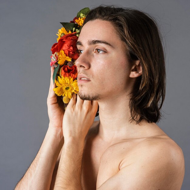 Side view of shirtless man with flower crown