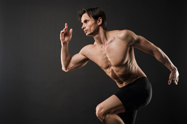 Side view of shirtless muscled man posing