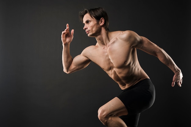 Side view of shirtless muscled man posing