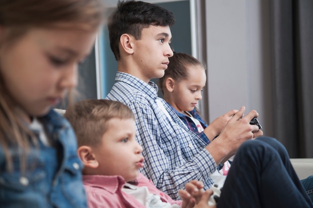 Free photo side view siblings playing video games