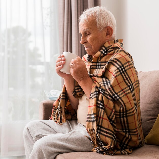 Side view sick man holding cup