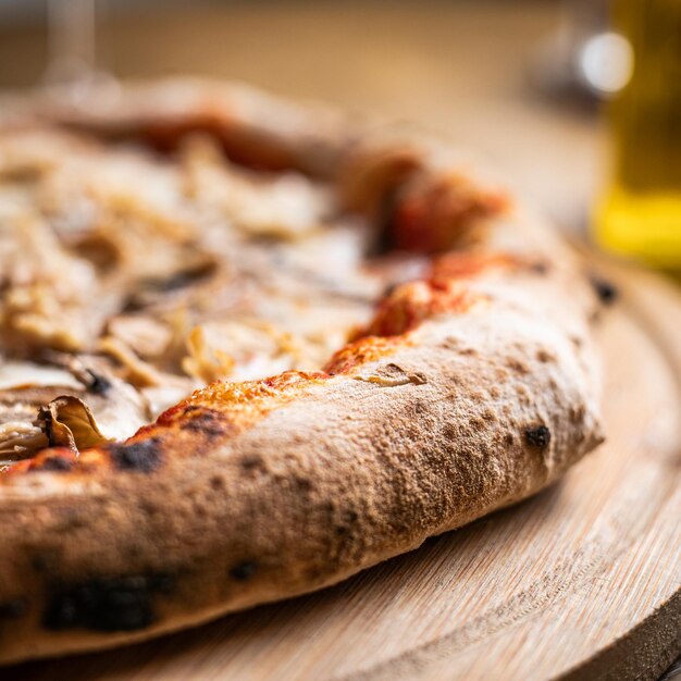 Side view of slice of pizza on wooden board