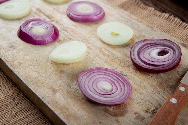 Side view of sliced onions on wooden surface on sackcloth background