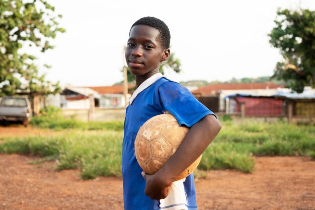 Side view smiley boy holding ball