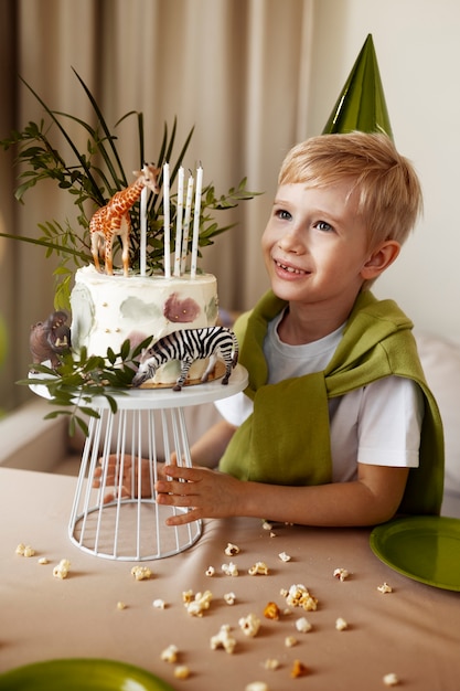 Free photo side view smiley boy with cake