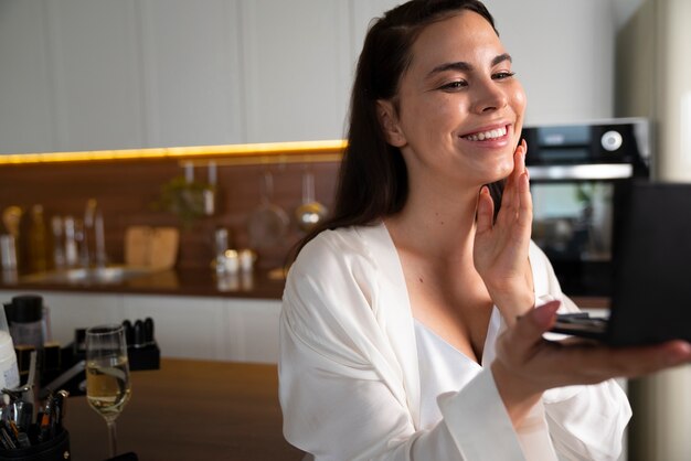 Foto gratuita sposa sorridente di vista laterale che guarda nello specchio