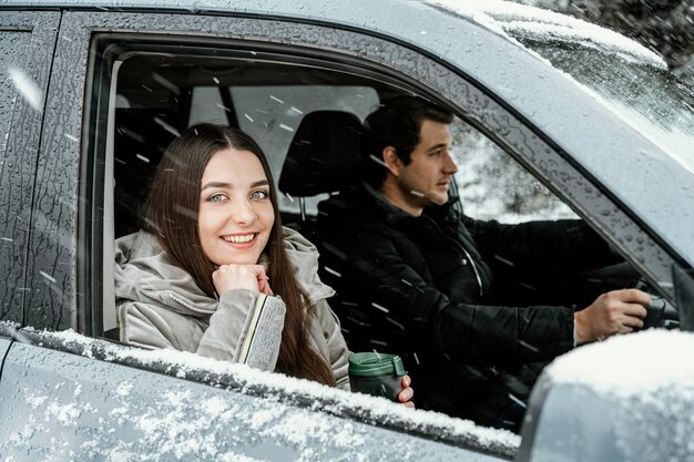 ロードトリップ中の車の中で笑顔のカップルの側面図