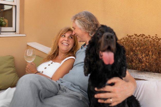 Coppia sorridente di vista laterale con il cane carino