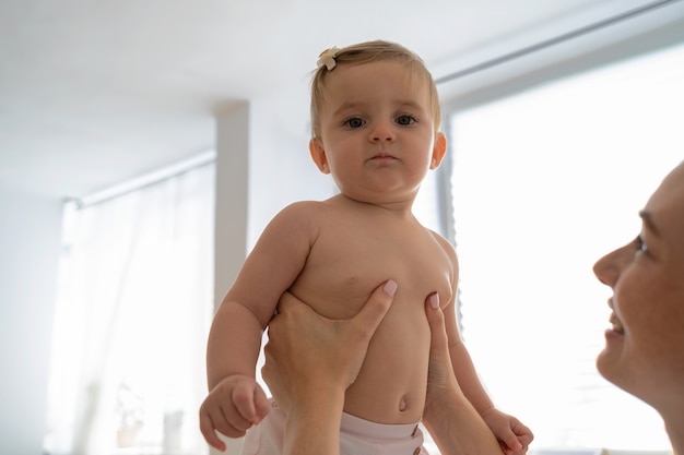 Free photo side view smiley doctor holding baby