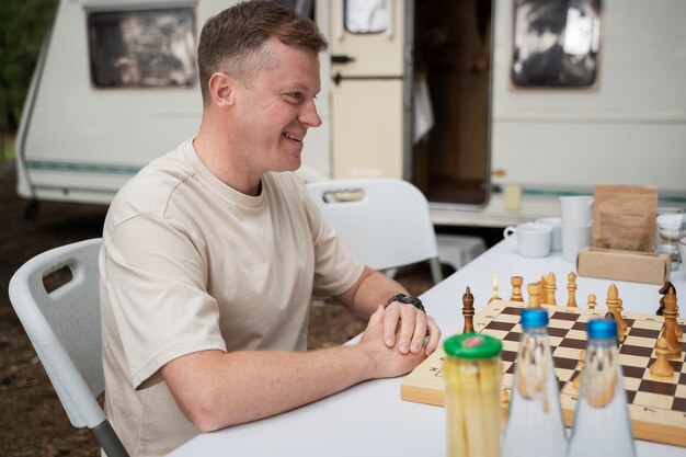 Side view smiley father playing chess