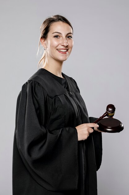 Side view of smiley female judge with gavel