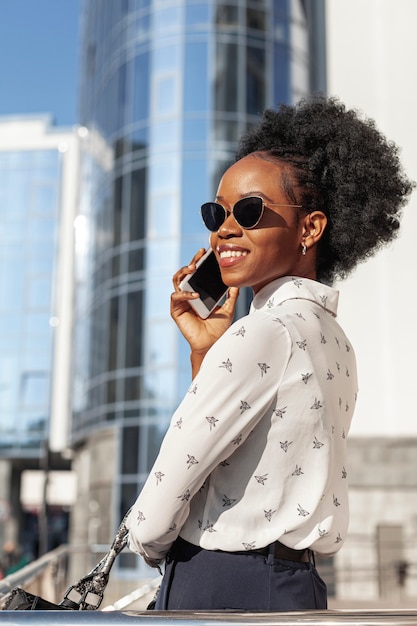 Free photo side view smiley female with phone