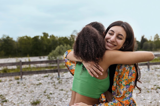 Side view smiley friends hugging