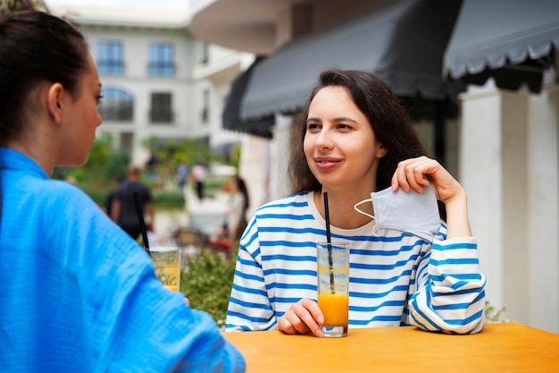 Free photo side view smiley friends with drinks