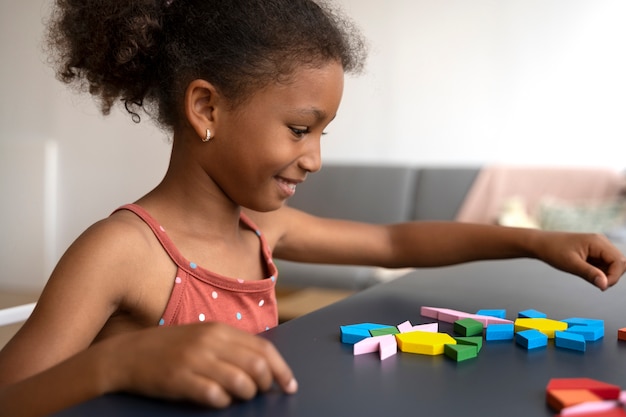 Side view smiley girl making puzzle