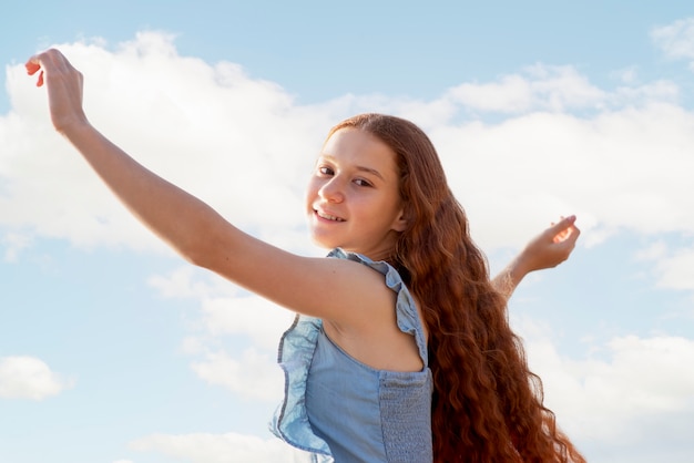 Foto gratuita ragazza sorridente di vista laterale all'aperto