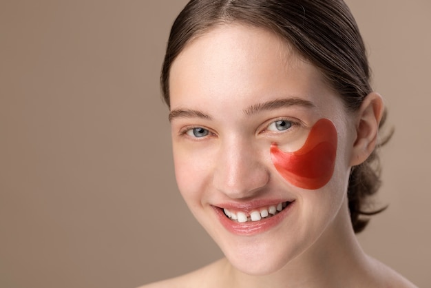 Foto gratuita ragazza sorridente di vista laterale che posa con la benda sull'occhio