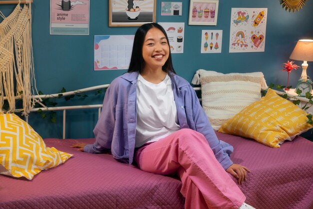 Side view smiley girl sitting in bed