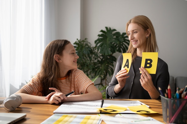 Free photo side view smiley girl and teacher