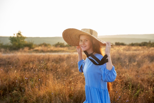 Free photo side view smiley girl wearing hat