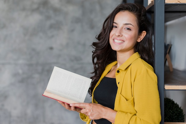 Ragazza di smiley di vista laterale con il libro