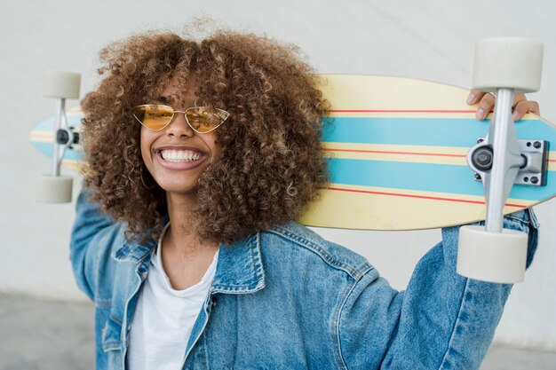 Side view smiley girl with skateboard