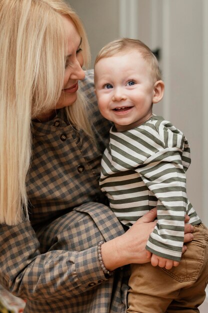 Side view of smiley grandmother holding her cute grandson