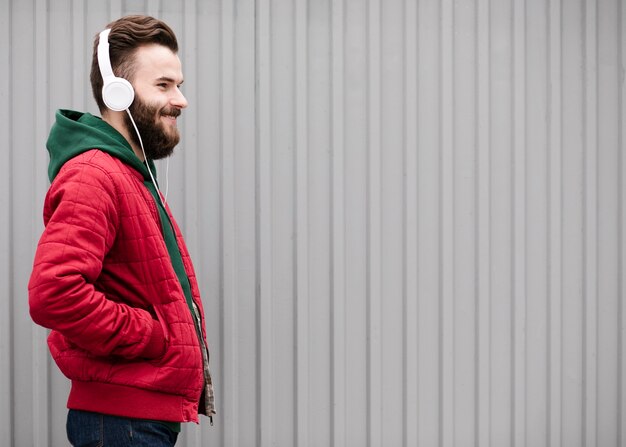 Side view smiley guy with beard and headphones