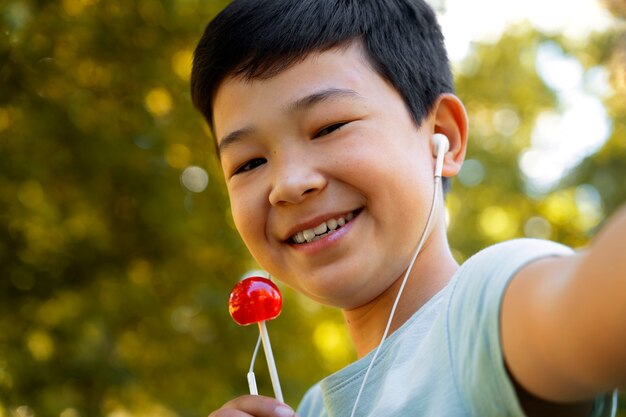 Side view smiley kid holding lollipop