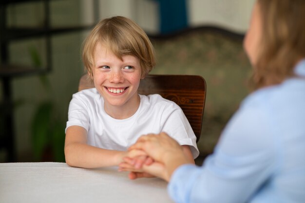 Side view smiley kid and teacher praying