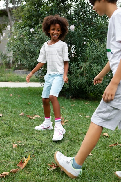 Foto gratuita bambini sorridenti di vista laterale che giocano all'aperto