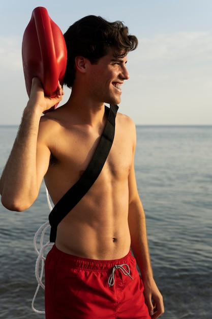 Side view smiley man holding lifesaving buoy