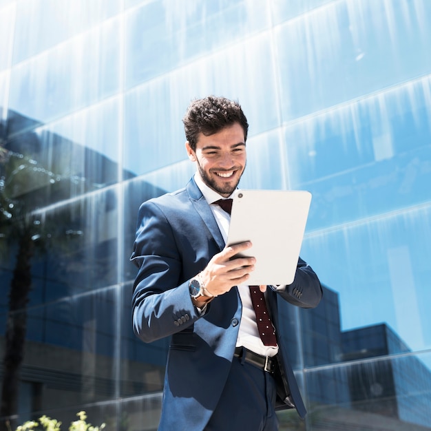 Side view smiley man looking at tablet