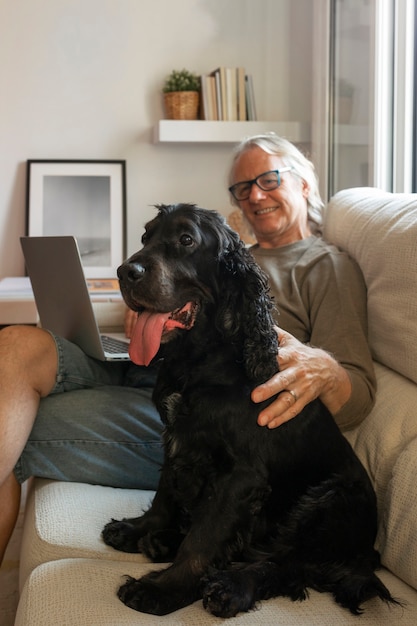 Foto gratuita uomo sorridente di vista laterale che accarezza il cane