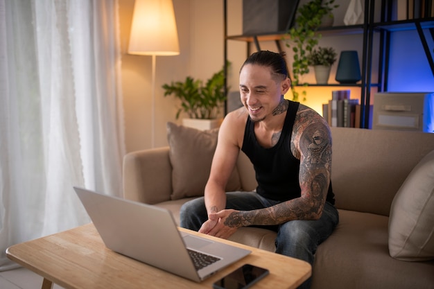 Free photo side view smiley man with laptop indoors