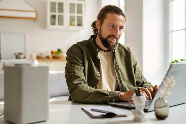 Side view smiley man working on laptop