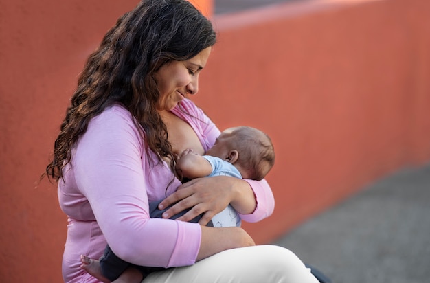 Side view smiley mother breastfeeding