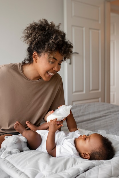 Side view smiley mother feeding baby