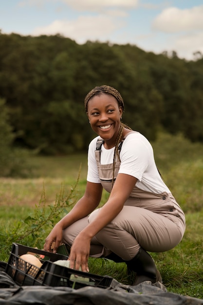 Foto gratuita donna contadina sorridente di vista laterale all'aperto