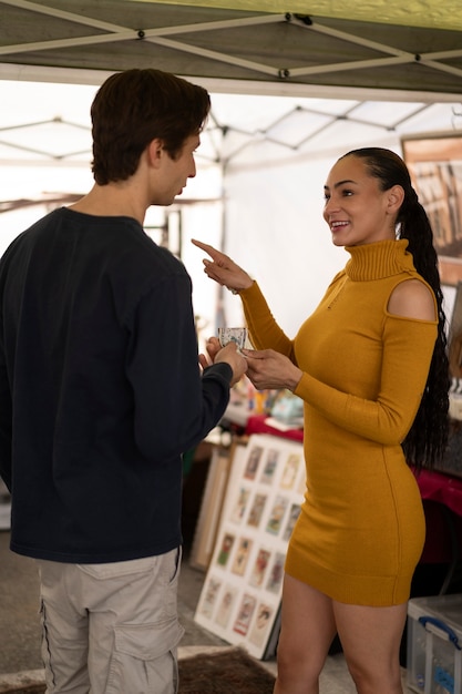 Free photo side view smiley people at flea market