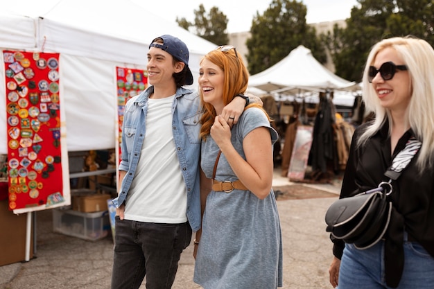 Free photo side view smiley people at flea market