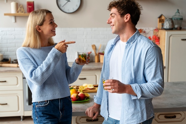 Free photo side view smiley people in kitchen