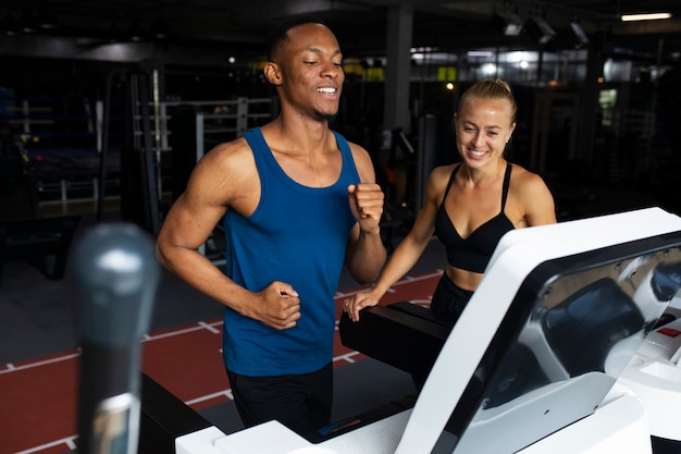 Foto gratuita persone sorridenti di vista laterale che si allenano in palestra