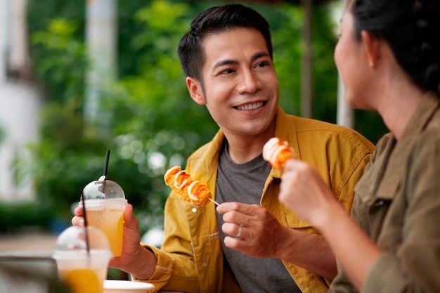 Free photo side view smiley people with food