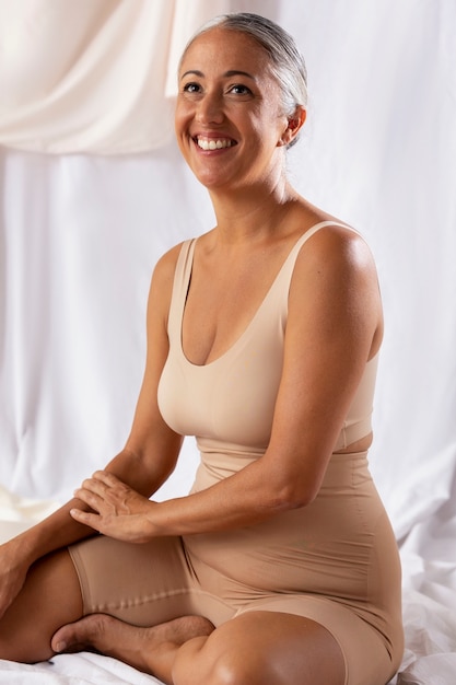 Free photo side view smiley senior woman wearing shapewear